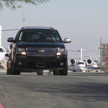 White planes behind a black van.