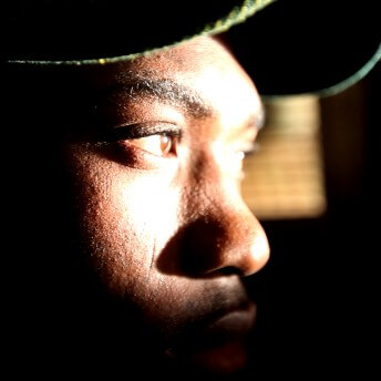 Close-up to the eyes of a person. The sun illuminates the person's eyesight while leaving the rest of their face in the shadows.