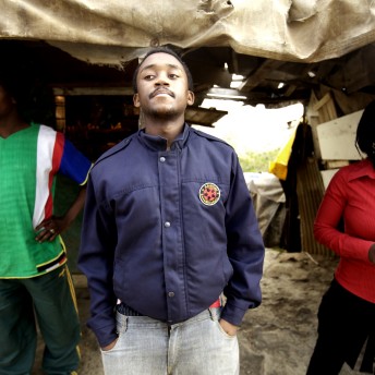 A man with a blue jacket standing in front of the camera.