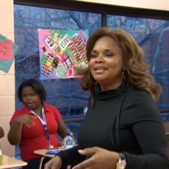 A woman talking to teenagers in a classroom.