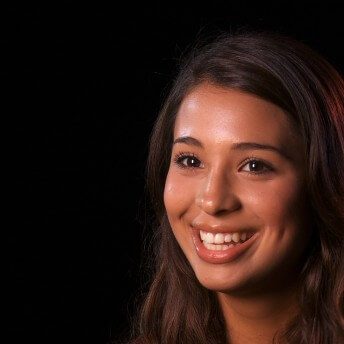 Still from Mariachi High. A woman is smiling and looking off camera.