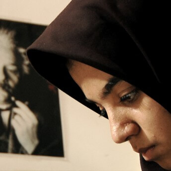 Profile shot of Sepideh looking down. In the background, there is an out-of-focus poster with Albert Einstein's portrait.
