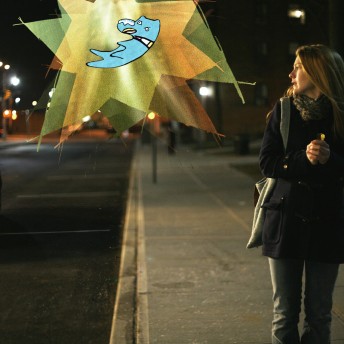Lily Rabe as Mona Peek looking at an animated, floating, glowing dog on an empty street at night. Color photograph.