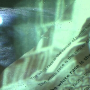 A page with text is overlapped with the light of a projection.