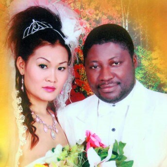 Still from A Guangzhou Love Story. A wedding photo of a woman and a man, both dressed in white. The woman is wearing a veil, jewelry, tiara, and is holding a bouquet.
