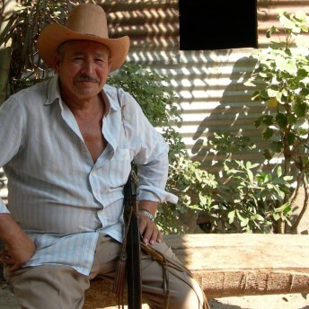 A man sitting on a bench, looking directly at the camera.