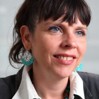 Judith Ehrlich faces the camera and looks slightly off to the side. Portrait in color.