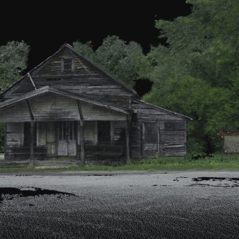 An abandoned cabin, surrounded by green vegetation.