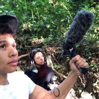 Production still from Silent Beauty. High-angle shot of director Jasmin Mara Lopez with headphones and a person holding a microphone.