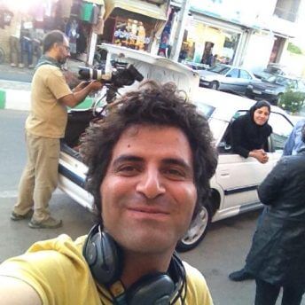 Selfie photo of Mohammad Reza, and Sara Khaki in the background peeking out from a car window.