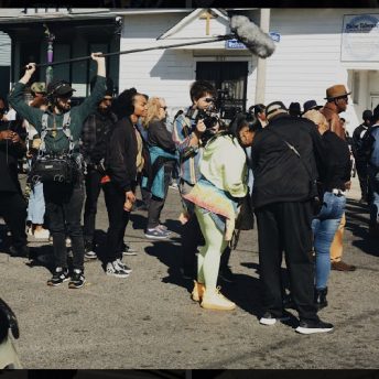 A soundperson holds a microphone over a group of people.