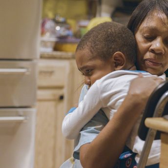 Still from Through the Night. A woman hugs an infant.
