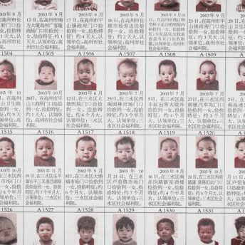 Still from One Child Nation. Photograph of a printed graphic of a grid with pictures of infants and text in Chinese.