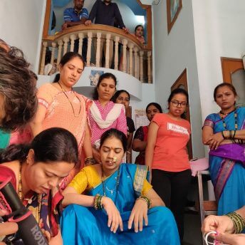 Production shot of Against the Tide. Low angle shot of a group of woman looking at a person with a rhode microphone, on an interior balcony there are two men watching them.