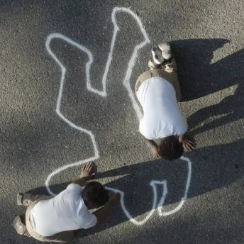 Still from Since I Been Down. Aerial shot of two men kneeling on the concrete, drawing with chalk the silhouette of a human body.