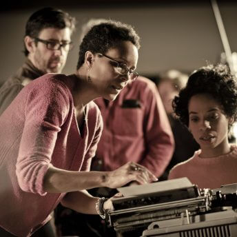 Tracy Heather Strain on set directs actress portraying Lorraine Hansberry at an old typewriter.
