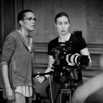 Tracy Heather Strain reviews camera monitor with female DP in black and white photo.
