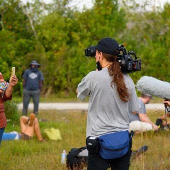Jesse and Sasha document Betty during an action she is leading in the Big Cypress in an open green field
