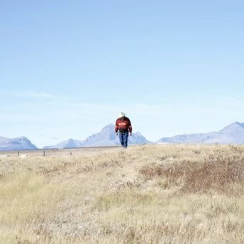 Kenny Still Smoking is seen walking in the foreground near a place, on the Blackfeet Reservation, where he searched for his daughter Monica when she went missing.