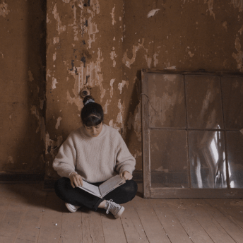 Director Gabriela Pena reading her grandfather’s memoirs at the run-down family house.