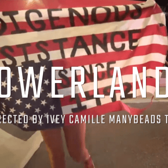 Still from the film Powerlands, a person holds a US flag that is upside down and says Indigenous Resistance since 1492, on top of it there is the title of the film and the name of the director