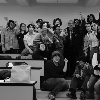 Actors and crew members raising their gists in front of the camera