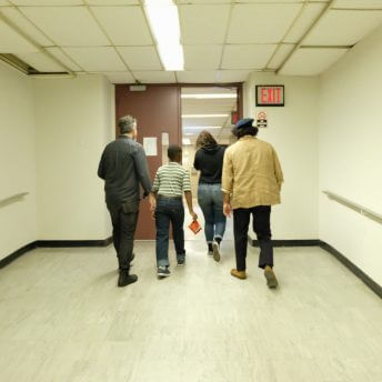 Producer Toby Gerber, Director Emma Francis-Snyder, and two actors walking in a hallway