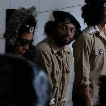 Medium shot of actors wearing jackets and berets