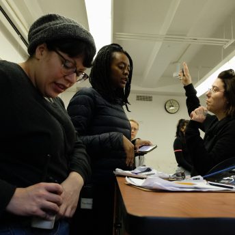 Low angle shot of the production team of Takeover, with papers over a table