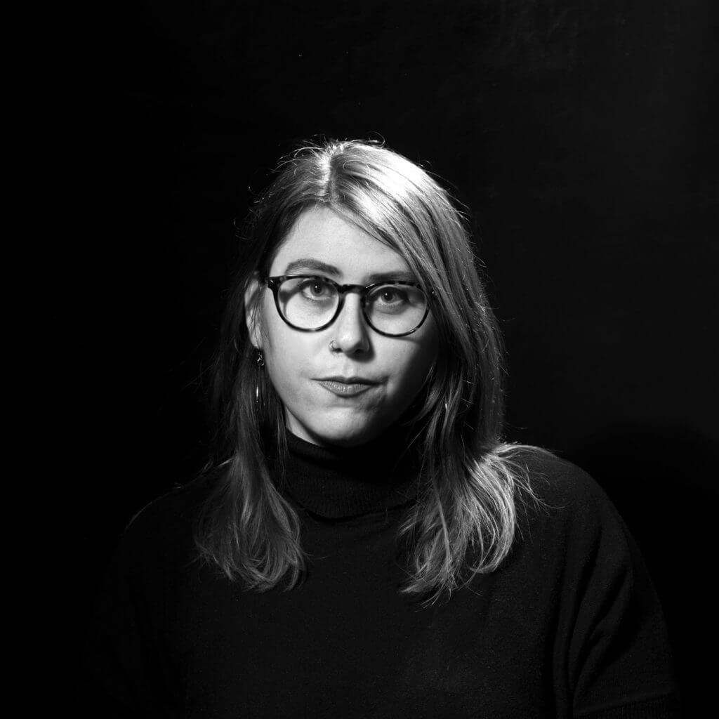 Headshot of Emma Francis-Snyder, she looks directly at the camera, has medium length hair, and frames.