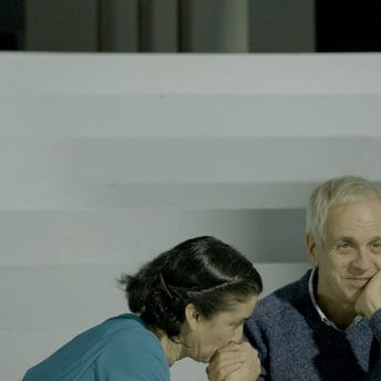 Still from The Eternal Memory. Paulina and Augusto sitting on the steps of a set.