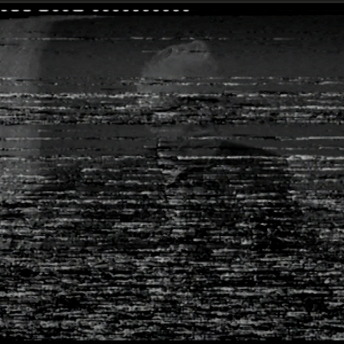 Heavily damaged VHS archive image of a man with white hair and dark suite. The face is unrecognizable because of the white noise caused by the damage.