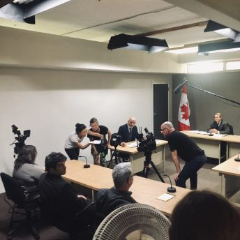 Production still of Sonia Kennebeck directing recreation scenes with actors.