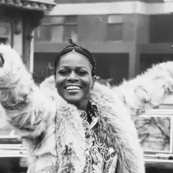 Diahann Carroll smiling with her arms in the air