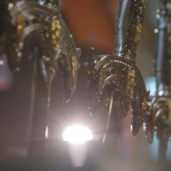 Line-up of swords with spot-light behind.