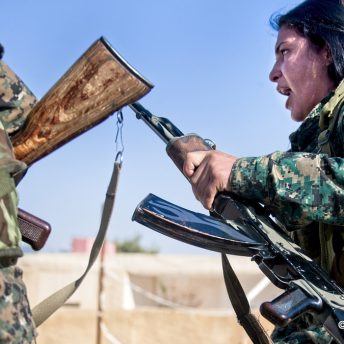 Two women hold their guns against each other.