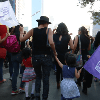 A mother marches with her two daughters across one of the most important avenues in Mexico City.