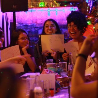 A group of women participate in a drink and drew activity after the international women's day march.