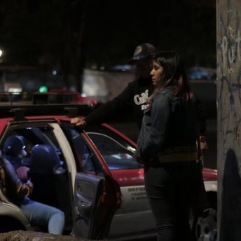 Fernanda waits to board a collective taxi to get home at night.