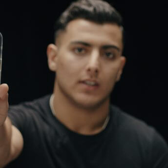 We see Sajid Khan holding up his phone, showing us a picture of himself when he was younger in Afhanistan. He was a child then, he's become a man now.