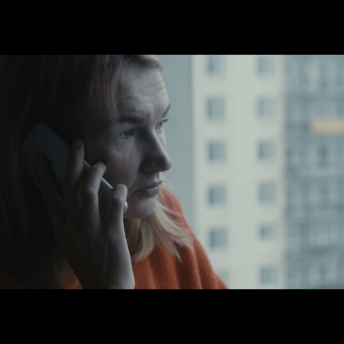 Maris makes a phone call in a hotel room.