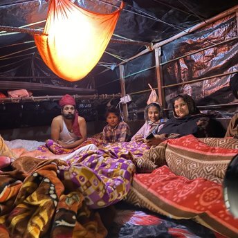 A family inside a tractor-trailer on a winter night on the Delhi border during the farmers' protests.